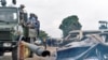 Le personnel de sécurité assis sur un camion surveille les véhicules brûlés lors de l’évasion spectaculaire du chef de la secte Bundu dia Mayala Ne Muanda Nsemi à Kinshasa, République démocratique du Congo, 17 mai 2017.