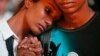 A boy comforts a crying girl during a special prayer for the passengers of the missing Malaysia Airlines flight MH370 in central Kuala Lumpur, March 18, 2014