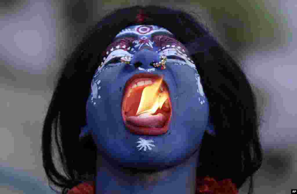 An Indian man dressed as Hindu Goddess Kali puts fire in his mouth during a procession to celebrate the Ram Navami festival in Allahabad, India.