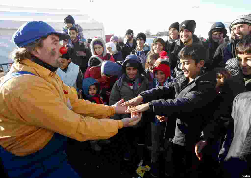 A member of Red Noses Clowndoctors entertains migrants at a registration center in Dobova, Slovenia,&nbsp;before their departure to Austria.