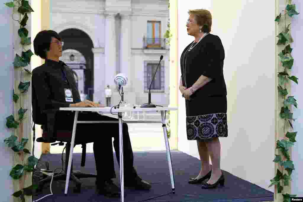 Chile&#39;s President Michelle Bachelet talks to a Geminoid HI-2 robot, which is made in likeness of its creator, Japanese professor Hiroshi Ishiguro (not pictured), during the opening ceremony of the Congress of the Future event in Santiago.