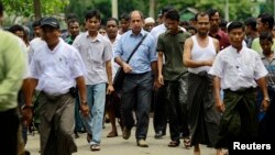 Tomas Ojea Quintana (C), United Nations Special Rapporteur on the human rights situation, walks with Rohingya Muslims as he visits Aung Mingalar in Sittwe, Burma, August 13, 2013. 