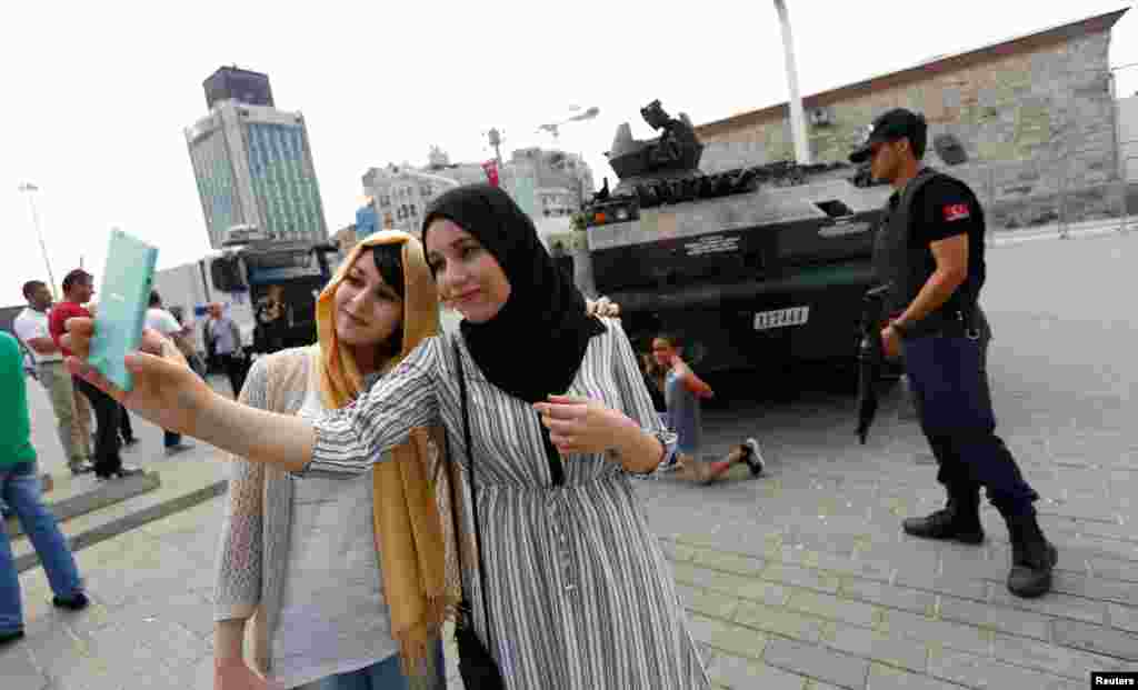 Turis-turis Aljazair mengambil swafoto di depan tank yang terbengkalai setelah kudeta yang digagalkan, di Lapangan Taksim di Istanbul, Turki (17/7).&nbsp;(Reuters/Murad Sezer)
