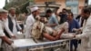FILE - A wounded man is brought by stretcher into a hospital after an explosion at a mosque in Haskamena district of Jalalabad, east of Kabul, Afghanistan, Oct. 18, 2019. 