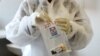 FILE - A health worker holds a COVID-19 sample collection kit of a vaccine trial volunteer, after a test for the coronavirus disease, at the Wits RHI Shandukani Research Centre in Johannesburg, South Africa, Aug. 27, 2020.