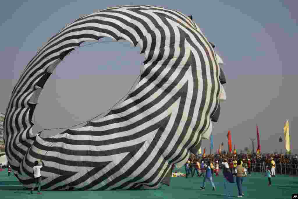 A huge kite is prepared to fly on the opening day of the International Kite Festival in Ahmadabad, India.