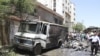 Residents and security personnel gather at the site of an explosion at al-Thawra street in Qudsiya suburb, near Damascus, in this handout released by Syria's national news agency SANA, June 8, 2012. 
