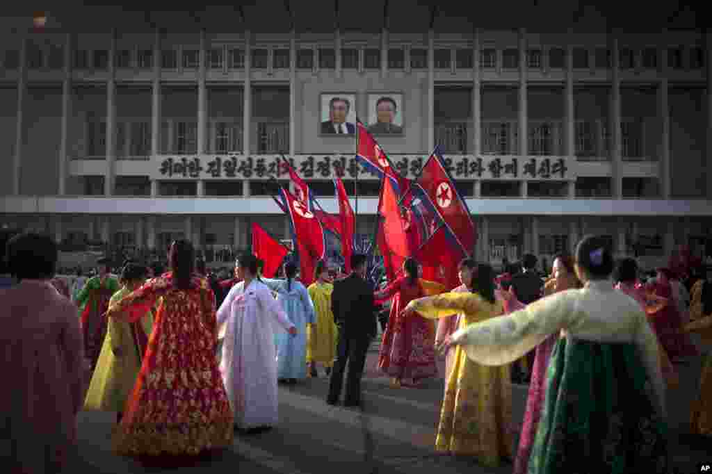A man, center, supervises a dancing group during a mass folk dance in front of the Pyongyang Indoor Stadium, April 15, 2013. 