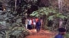 Des policiers encadrent un groupe d’homme près des tombes nouvellement creusées dans la jungle à Ndenga Mongo, province de Kasaï, RDC, 4 août 2007. 