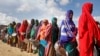 FILE - Women who fled drought queue to receive food distributed by local volunteers at a camp for displaced persons in the Daynile neighborhood on the outskirts of Mogadishu, in Somalia, May 18, 2019. 