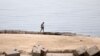 FILE - A man walks along one of the beaches that have been closed after a Russian citizen was killed in a shark attack near a beach at the Egyptian Red Sea resort of Hurghada, June 9, 2023.