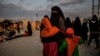 FILE - A veiled woman with children is seen at al-Hol camp in al-Hasakeh governorate in northeastern Syria, Feb. 17, 2019.