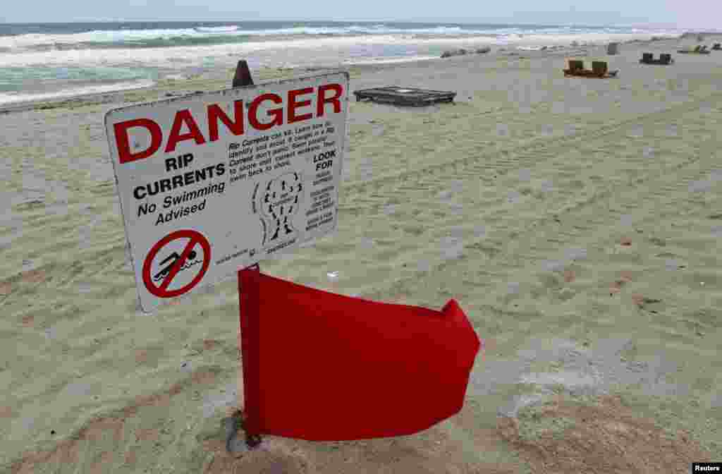 Bendera merah dikibarkan setelah penjaga pantai menetapkan larangan berenang karena ombak yang berbahaya akibat angin dari Badai Sandy yang mempengaruhi cuaca di Pantai Deerfield, Florida (25/10).