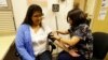 In this photo taken Thursday, April 11, 2013 Liz DeRouen, 49, left, gets her blood pressure checked by medical assistant Jacklyn Stra, right, at the Sonoma County Indian Health Project in Santa Rosa, Calif. The Indian Health Service, whose funding could b