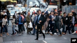 FILE - Pedestrians cross a road in Sydney, Australia, Sept. 6, 2017. Australia's population has reached 25 million for the first time, according to official estimates.