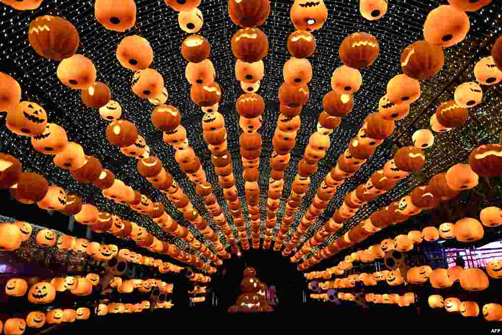 Para pengunjung melewati lentera-lentera yang dibuat dari labu untuk memperingati &#39;Halloween&#39; di pusat perbelanjaan di Shenyang, Liaoning, China.