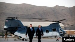 FILE - Secretary of State Mike Pompeo walks from a helicopter with U.S. Ambassador to Afghanistan John Bass, as Pompeo returns to his plane after an unannounced visit to Kabul, Afghanistan, June 25, 2019.