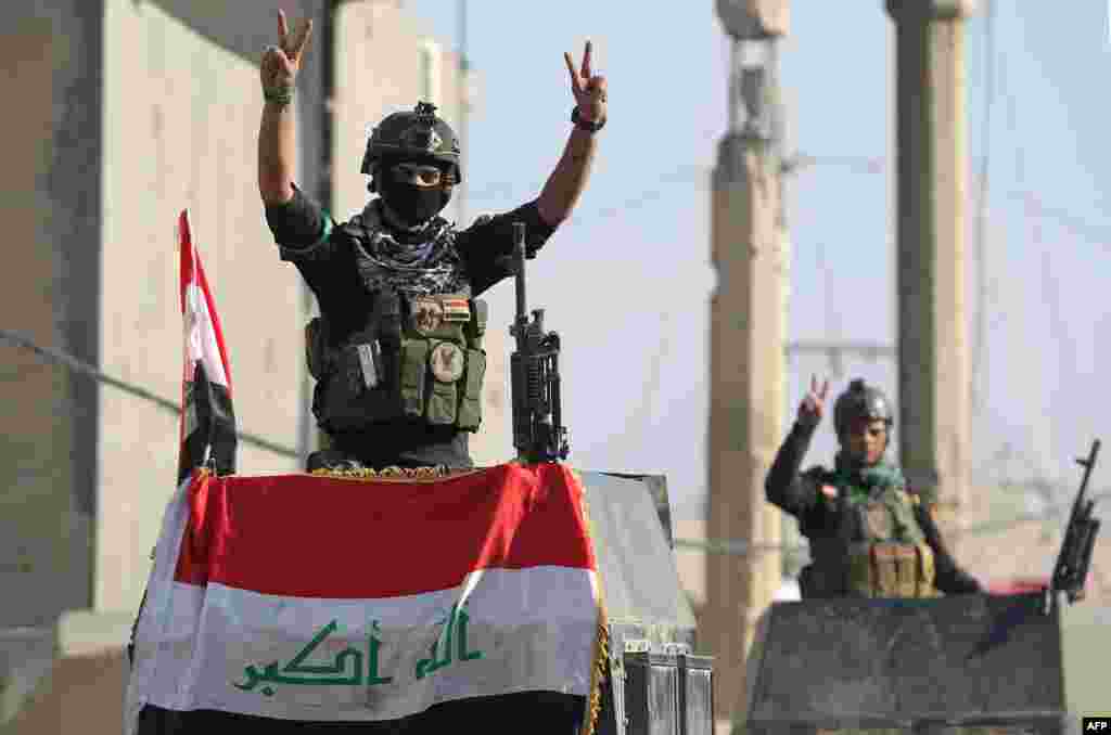 Members of Iraq's elite counterterrorism service flash the "V" for victory sign in the city of Ramadi, the capital of Iraq's Anbar province, about 110 kilometers west of Baghdad, after recapturing it from the Islamic State jihadist group.