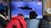 People watch a TV showing a file image of North Korea's missile launch during a news program at the Seoul Railway Station in Seoul, South Korea, Jan. 25, 2022.