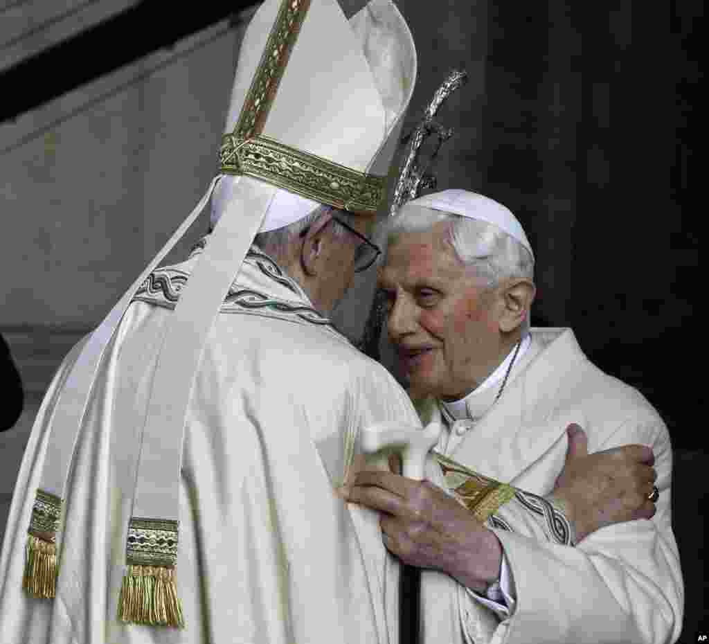 Pope Emeritus Benedict XVI, right, hugs Pope Francis in St. Peter's Basilica during the ceremony marking the start of the Holy Year, at the Vatican.