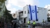 Radnik hitne pomoći fotografiše izraelsku zastavu postavljenu na zid oštećene zgrade u Kiryat Bialik u okrugu Haifa u Izraelu, nakon izvještaja o napadu libanonskog Hezbollaha 22. septembra 2024.