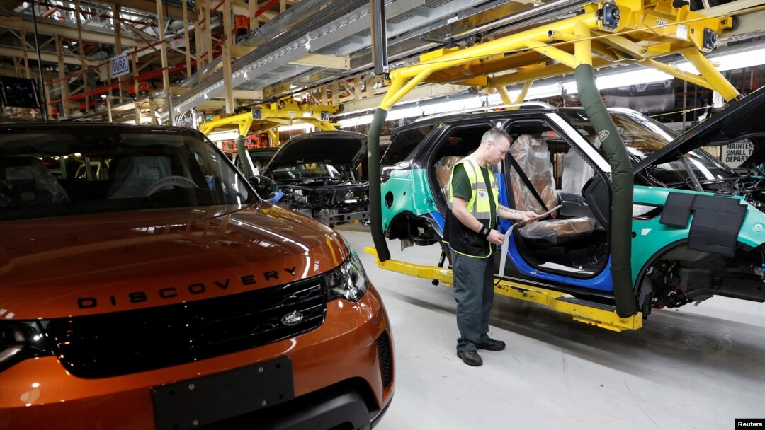 FILE - Worker George Baker looks at a build card for a vehicle destined for China at the Jaguar Land Rover facility in Solihull, England, Jan. 30, 2017. 