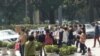Families gather outside the health department in the southern city of Guangzhou to petition against fines for couples who had more than one child before the country ended its one-child policy.